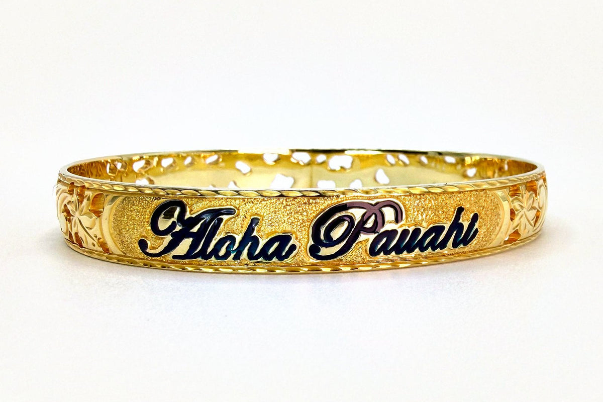 Aloha Pauahi gold Hawaiian heirloom bangle bracelet with a black enamel script name on a hand engraved band, handcrafted by Jewel Box Hawaii in Honolulu.