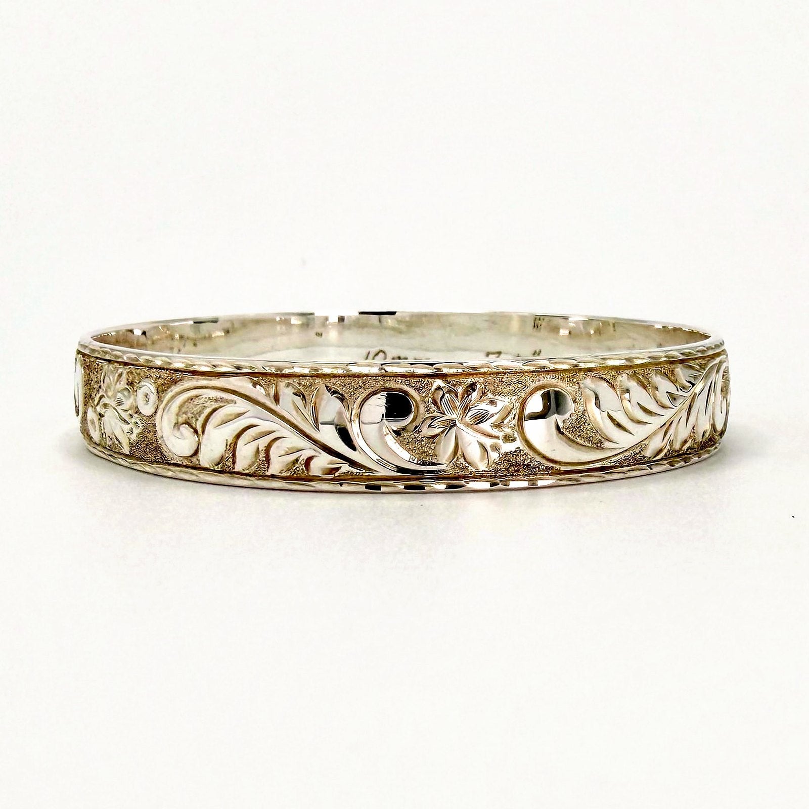 Sterling silver 10mm Hawaiian heirloom bangle bracelet with high relief blossom and leaf scroll hand engraving, handcrafted by Jewel Box Hawaii in Honolulu.