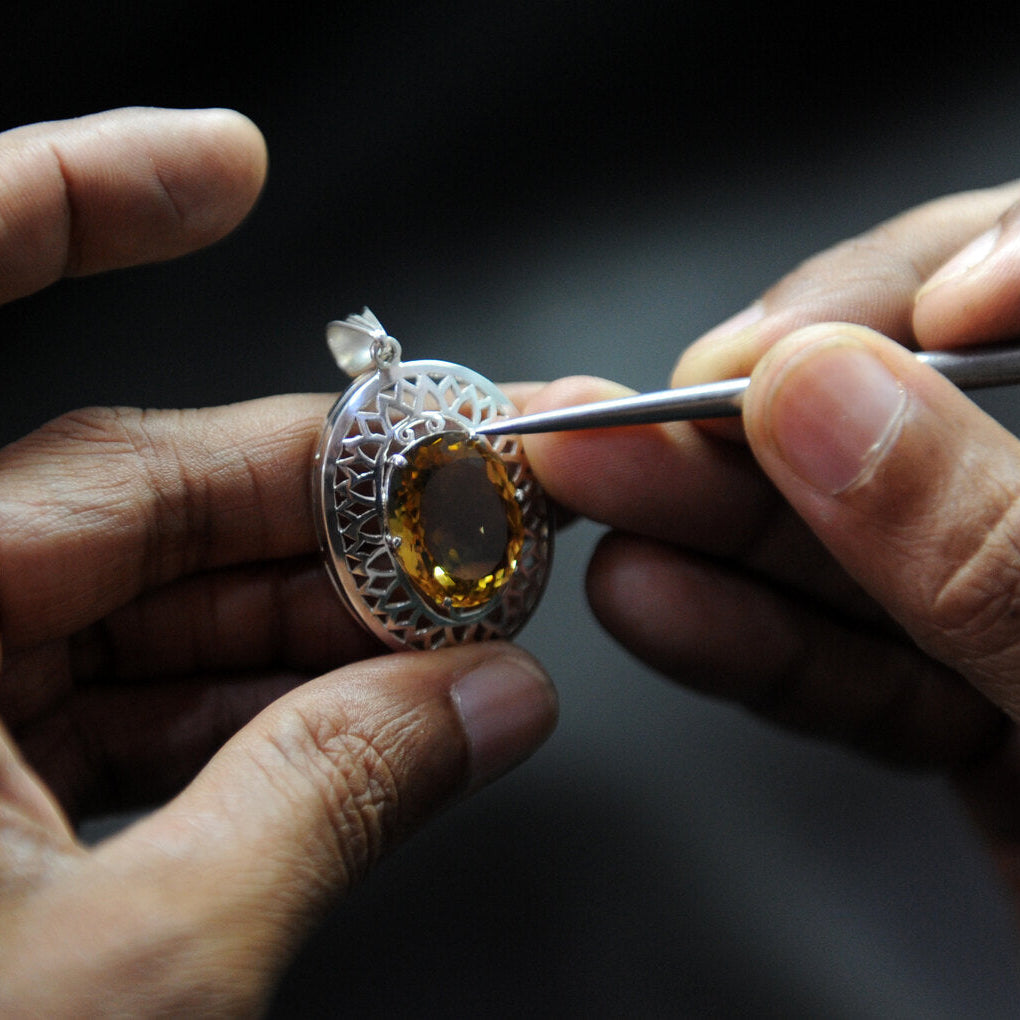 Jeweler setting a citrine stone into a silver ring during a jewelry repair in Honolulu