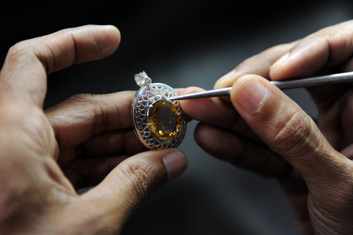 Jeweler setting a citrine stone into a silver ring during a jewelry repair in Honolulu