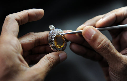 Jeweler setting a citrine stone into a silver ring during a jewelry repair in Honolulu