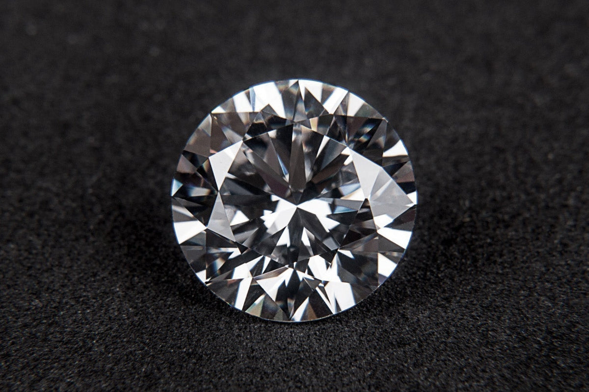 Round brilliant cut diamond on a dark textured surface, April's birthstone